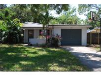 Charming one-story home with a well-maintained lawn, lush landscaping, and an attached garage at 6326 55Th N Ave, St Petersburg, FL 33709