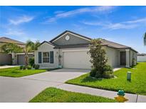 Charming single-story home with a two-car garage, well-manicured lawn and pretty landscaping at 742 8Th Nw St, Ruskin, FL 33570