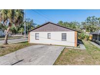 Front exterior view showing a driveway and a brown roof at 8317 N Marks St, Tampa, FL 33604