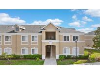 Inviting condo building with tan exterior, white trim, well-maintained landscaping, and visible unit number at 9519 Newdale Way # 202, Riverview, FL 33578
