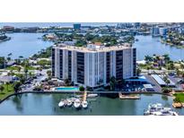 Panoramic aerial view of a waterfront condo building with a pool, boat docks and stunning coastal scenery at 10355 Paradise Blvd # 502, Treasure Island, FL 33706