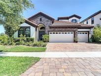 Charming single-Gathering home with a stone facade, tile roof, and well-manicured landscaping at 13706 Osprey Fern Ln, Riverview, FL 33569