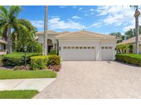 Charming single-story home featuring a three-car garage, well-manicured landscaping, and tile roof at 13872 Siena Loop, Lakewood Ranch, FL 34202
