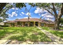 Beautiful single-story home boasts lush landscaping, brick accents, and a well-manicured lawn at 17917 Clear Lake Dr, Lutz, FL 33548