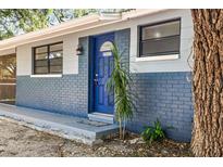 Charming home featuring a blue front door, blue painted brick and an inviting covered entryway at 2305 N 48Th St, Tampa, FL 33605