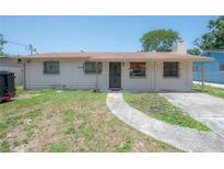 Modest single-story home with a walkway leading to the front door and bars on the windows at 2614 E Liberty St, Tampa, FL 33612