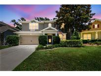 Charming two-story home featuring a well-manicured lawn, mature trees, and an attached two-car garage at 3530 Brook Crossing Dr, Brandon, FL 33511