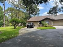 Charming home exterior featuring a well-manicured lawn, stone accents and a driveway with ample parking space at 3902 Shoreside Cir, Tampa, FL 33624