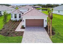 Stunning home with a clay tile roof, paver driveway, mature landscaping, and a lake view at 4709 Isonzo Way, Wesley Chapel, FL 33543
