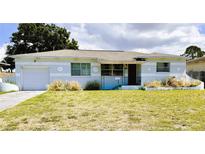 Charming single-story home with light blue paint, attached garage, and decorative flower trim at 5711 9Th N Ave, St Petersburg, FL 33710