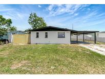 Charming single-story home featuring a carport and a well-maintained front lawn at 6403 N Lois Ave, Tampa, FL 33614