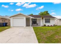 Charming single-story home featuring a well-manicured lawn and a welcoming front porch at 6433 Reef Cir, Tampa, FL 33625