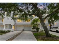 Inviting exterior showcasing well-maintained townhomes with garages and mature trees, creating a serene street view at 9812 Indian Key Trl # 84, Seminole, FL 33776
