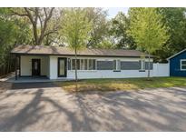 Charming single-story home with well-maintained lawn, carport, and brick accents near the front entry at 10406 N Boulevard, Tampa, FL 33612
