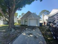 Charming single Gathering home features an attached garage, gray exterior and mature landscaping at 10912 Brightside Dr, Tampa, FL 33624