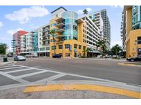 View of the colorful modern condo building with sidewalks and street traffic on a sunny day at 1120 E Kennedy Blvd # 1127, Tampa, FL 33602