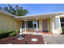 Inviting front porch area featuring brick flooring, decorative angel statue and blue shutters at 1444 Eastfield Dr, Clearwater, FL 33764