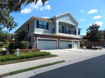 Two-story townhome showing three-car garage with stone veneer and covered second story balcony at 16618 Kingletside Ct, Lithia, FL 33547