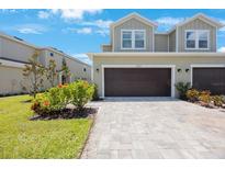 Inviting two-story townhome with a two-car garage and paver driveway at 1897 Trailside Dr, Palm Harbor, FL 34683