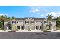 A stunning exterior view of the townhome community with landscaping and individual garages at 259 Royal Spoonbill Dr, Ruskin, FL 33570