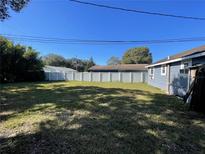 Large backyard featuring a well-maintained lawn and secured by a white privacy fence at 2678 62Nd N Ave, St Petersburg, FL 33702