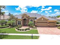 Charming home with manicured lawn, mature palms and brick paver driveway and entry in a gated community at 3123 Whitehead Ln, Land O Lakes, FL 34638