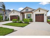 Charming home featuring a two-car garage, well-manicured landscaping, and a welcoming facade at 33487 Azalea Ridge Dr, Wesley Chapel, FL 33545