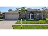 Charming single Gathering home with a well-maintained lawn, a two-car garage and inviting curb appeal at 5340 Riva Ridge Dr, Wesley Chapel, FL 33544