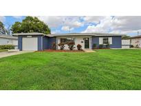 Charming blue single-story home with a well-manicured green lawn and inviting curb appeal at 6149 37Th N Ave, St Petersburg, FL 33710
