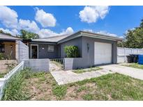 Cozy one-story home showcasing a charming gray exterior, a single-car garage, and a quaint, gated front yard at 702 Regent S Cir, Brandon, FL 33511