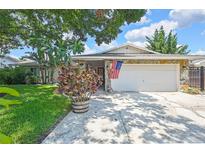 Charming home with a stone facade, large garage, and a well-manicured lawn at 7924 Singing Court Pl, Tampa, FL 33615