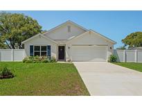 Charming single-story home featuring a well-manicured lawn, white exterior, and a two-car garage at 8508 Bay Dr, Spring Hill, FL 34606