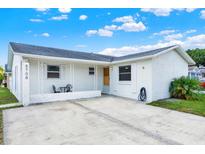 Charming single-story home featuring a covered front porch and a well-maintained concrete driveway and white facade at 8708 Albion Ct, Tampa, FL 33634