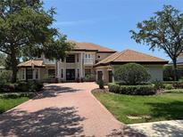 Stunning two-story home with tile roof, manicured lawn, and brick paved driveway, showcasing classic architectural details at 1333 Playmoor Dr, Palm Harbor, FL 34683