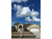 Charming one-story home showcasing a well-maintained lawn and a welcoming two-car garage at 13632 Deventer Ct., Hudson, FL 34667
