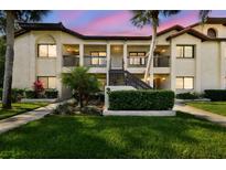 Condo complex showcasing a two-story building with well-maintained landscaping and inviting front entrances at 1801 E Lake Rd # 3A, Palm Harbor, FL 34685