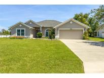 Charming one-story home with a lush green lawn and two car garage at 3095 Coronet Ct, Spring Hill, FL 34609