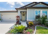 Charming single Gathering home with welcoming front entrance, beautiful landscaping and a two car garage at 3611 Natural Trace St, Plant City, FL 33565