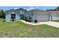 Charming light blue single-Gathering home with a well-maintained lawn and an attached two-car garage at 4214 Foxboro Dr, New Port Richey, FL 34653