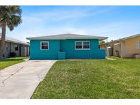 Charming single-story home featuring a well-manicured front yard and a vibrant blue exterior at 5051 Bonito Dr, New Port Richey, FL 34652