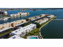 Breathtaking aerial view of waterfront condos with a community pool and boat docks, nestled amidst beautiful waterways at 7465 Bay Island S Dr # 213, South Pasadena, FL 33707