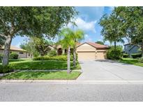 Charming single-story home featuring a three car garage, tile roof, and manicured front lawn at 9313 Lisbon St, Seffner, FL 33584