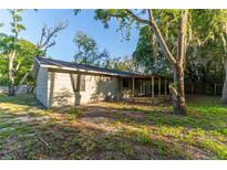 The backyard features a covered patio perfect for outdoor entertaining, surrounded by mature trees and lush greenery at 9834 Miramar St, New Port Richey, FL 34654