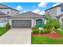 Charming single-story home featuring a well-manicured lawn and a welcoming turquoise-colored front door at 1015 7Th Nw Ave, Ruskin, FL 33570