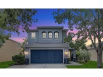 Charming two-story home with a blue two-car garage and well-maintained front yard and landscaping at 11121 Running Pine Dr, Riverview, FL 33569