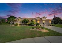 Charming single-story home with a well-manicured lawn and a tile roof at dusk at 1201 Peridot Ln, Sun City Center, FL 33573