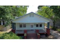 Charming bungalow with a spacious front porch and mature trees offering shade at 1221 E Osborne Ave, Tampa, FL 33603