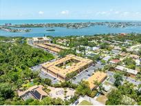 An aerial view of a condo community in a desirable location by the water and beach, near mature trees and landscaping at 12760 Indian Rocks Rd # 410, Largo, FL 33774