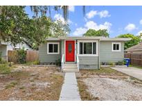 Charming home featuring a bright red front door and inviting curb appeal at 1408 Michigan Ave, Palm Harbor, FL 34683