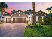 Beautiful single-story home featuring a three-car garage, well-manicured lawn, and tasteful stone and stucco accents at 1416 Via Verdi Dr, Palm Harbor, FL 34683